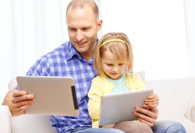 familia, hijos, paternidad, tecnología y concepto de internet - feliz padre e hija con tablet pc en casa