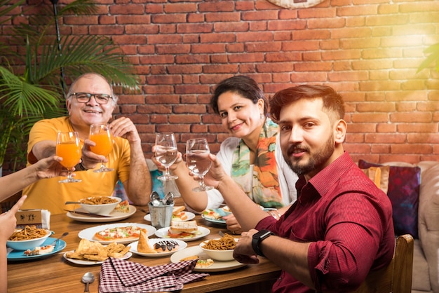 Familia india comiendo en la mesa de comedor en casa o en un restaurante comiendo juntos