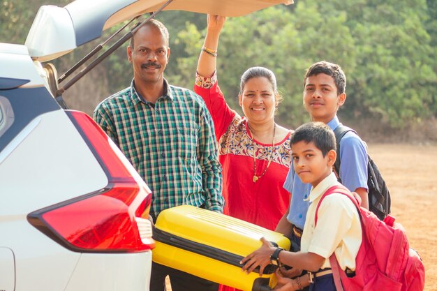 Familia india comprando un auto nuevo y lista para irse de vacaciones a la playa