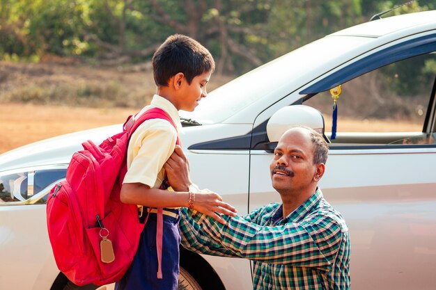 Familia india conduciendo niños a la escuela frente a las puertas de la casa