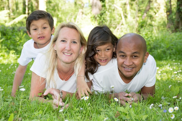 Familia india mixta de mentira en vacaciones de verano de hierba