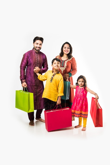 Família indiana celebrando Diwali ou Deepavali com roupas tradicionais com sacolas de compras, isolada sobre um fundo branco