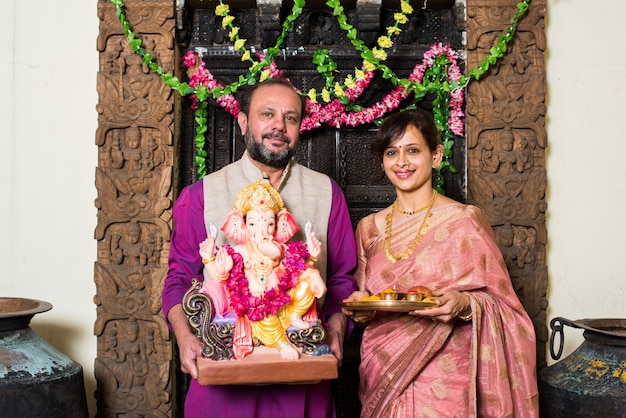 Família indiana celebrando Ganesh Chaturthi fazendo Ganpati Puja ou poojan