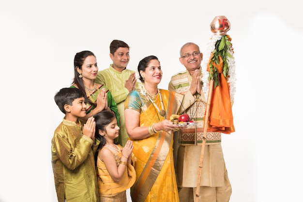 Família indiana celebrando o festival de Gudi Padwa ou Ugadi enquanto a senhora ou esposa segurando Puja ou pooja thali. É um novo ano na religião hindu