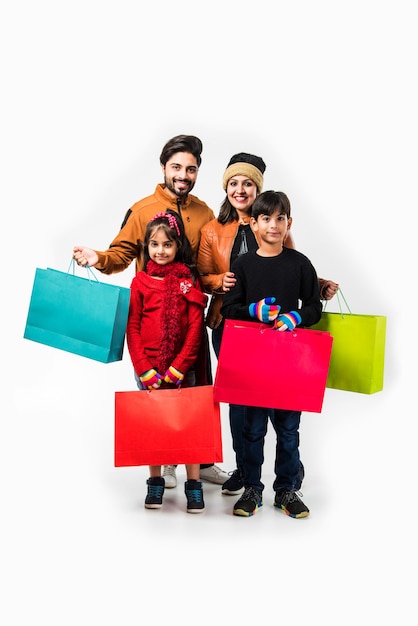 Família indiana com sacolas de compras no inverno e roupas quentes como pano de fundo