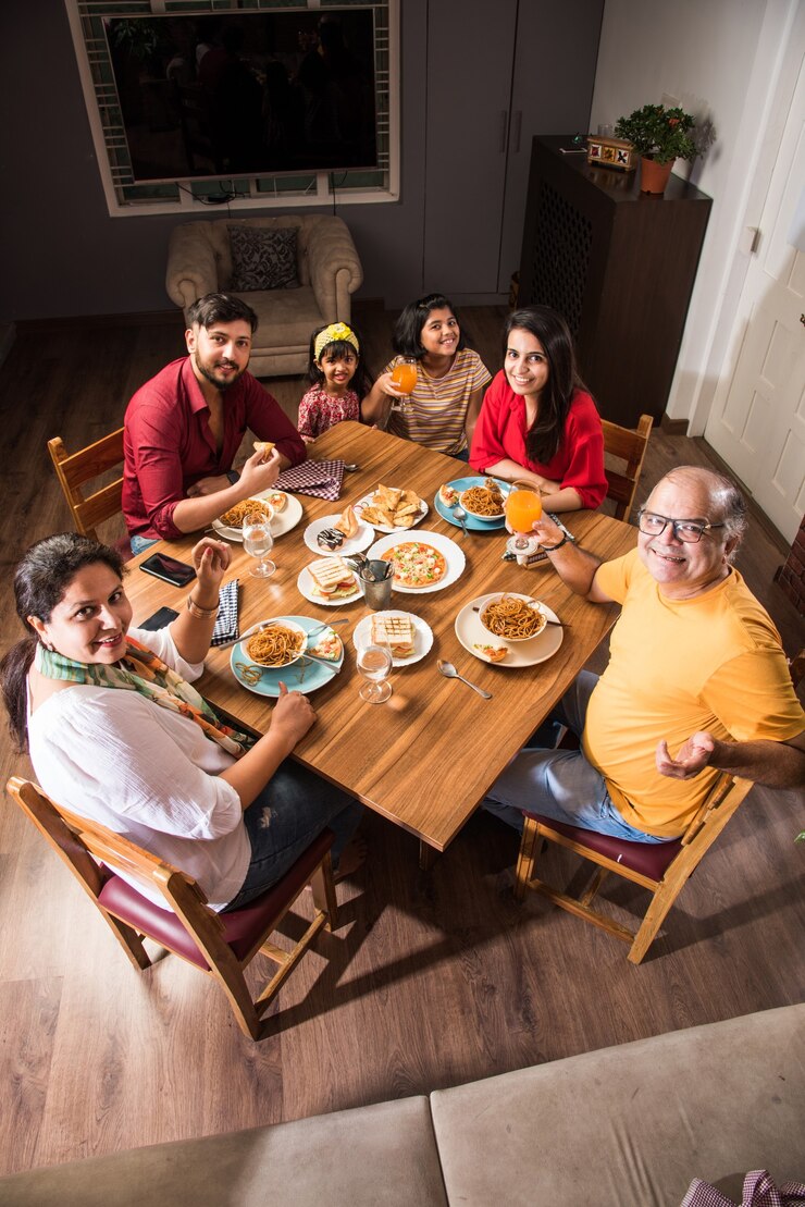 Foto família indiana comendo comida na mesa de jantar em casa ou restaurante fazendo as refeições juntos