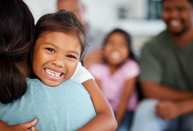 Família indiana e menina abraçam a mãe com sorriso feliz e riem animadas em casa Amo rir e homens e mulheres com filhos na Índia Pais e filhos divertidos relaxam no fim de semana mãe e filha juntos