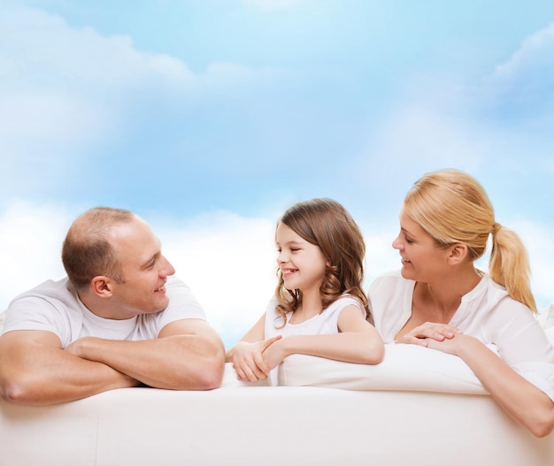 família, infância e pessoas - sorrindo mãe, pai e filha sobre fundo de céu azul