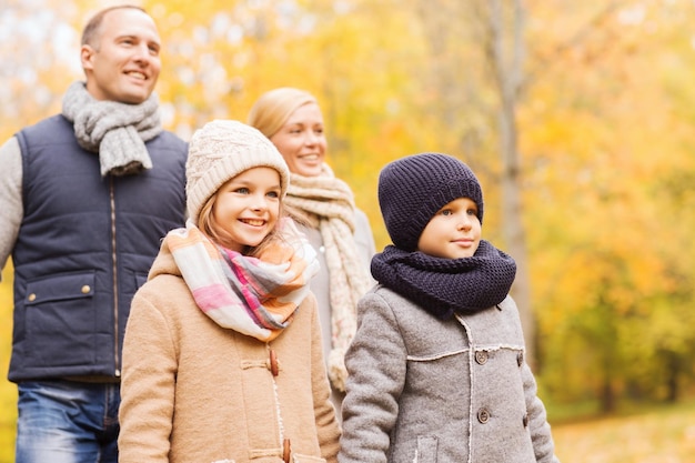 Família, infância, estação e conceito dos povos - família feliz no parque do outono