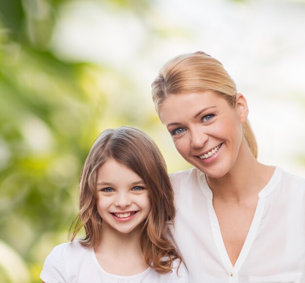 família, infância, felicidade, ecologia e pessoas - sorrindo, mãe e filha sobre fundo verde