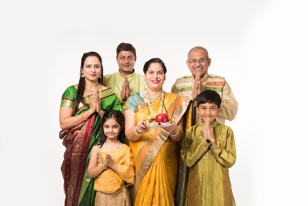 Família inteligente indiana asiática dando as boas-vindas ao Lord Ganesha Idol no Festival de Ganesh com Pooja Thali e doces. de pé isolado sobre fundo branco