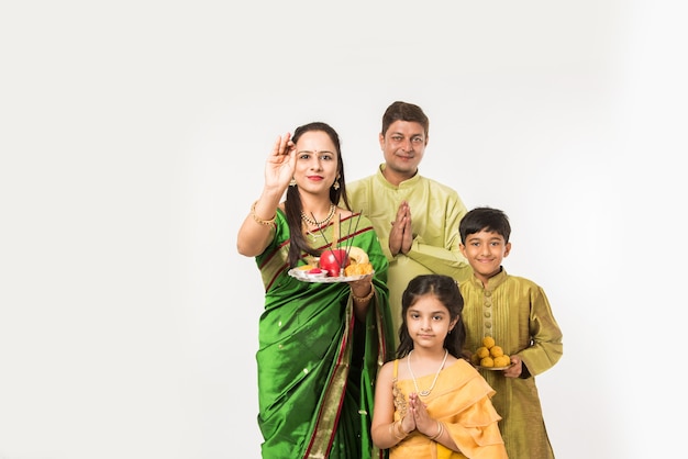 Família inteligente indiana asiática dando as boas-vindas ao Lord Ganesha Idol no Festival de Ganesh com Pooja Thali e doces. de pé isolado sobre fundo branco