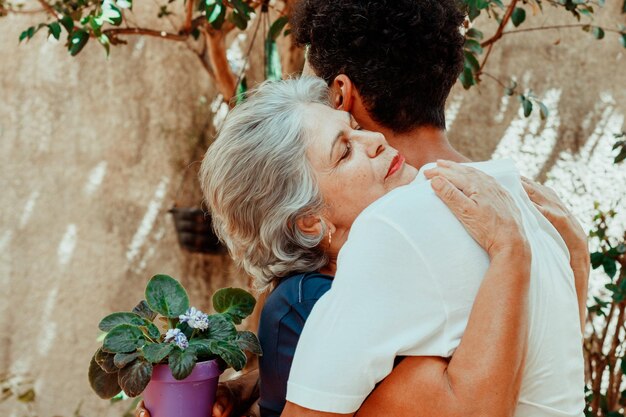 Familia interracial feliz Hijo le da un regalo a su madre en el jardín de la casa Madre caucásica y su foto de hijo negro