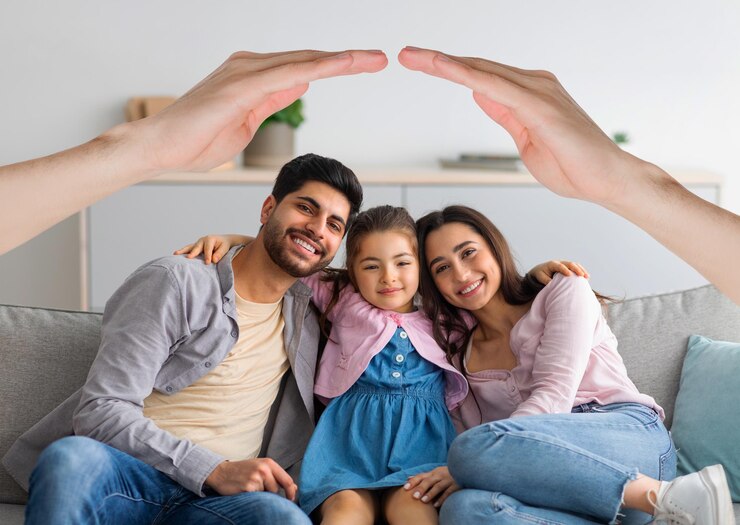 Foto família interracial feliz posando em casa sob o telhado das mãos