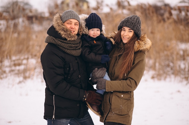 Familia en invierno en el bosque con hijo