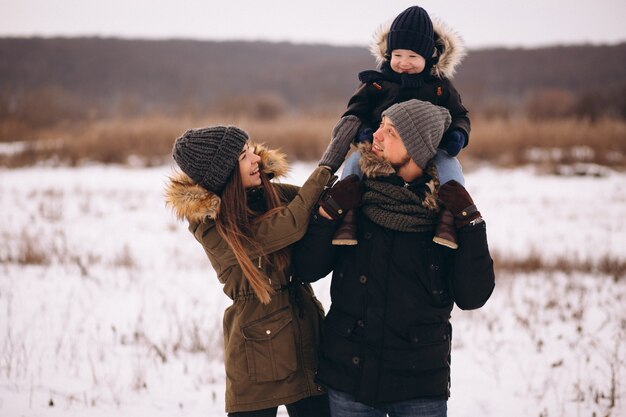 Familia en invierno en el bosque con hijo