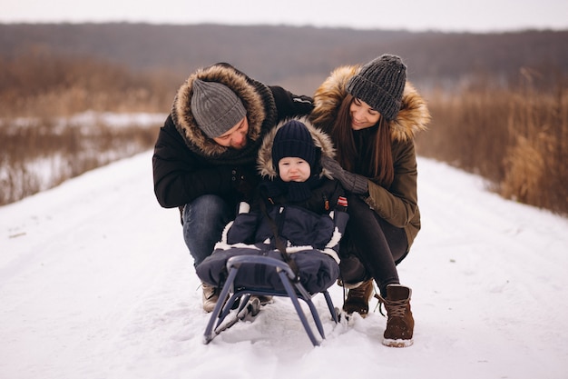 Familia en invierno con trineo hijo