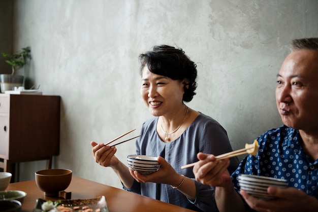 Familia japonesa cenando juntos con felicidad