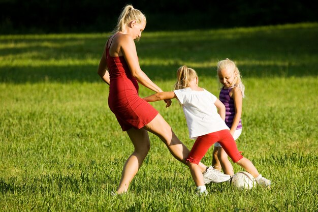 Família jogando futebol em um campo de grama