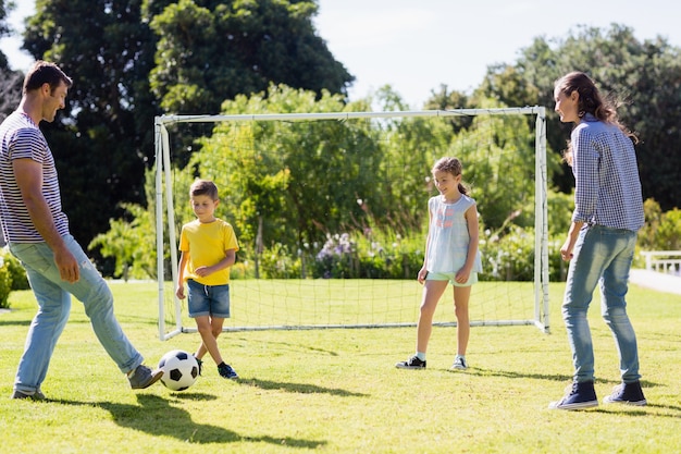 Família jogando futebol junta no parque