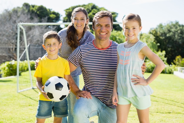 Foto família jogando futebol junta no parque