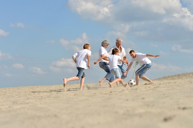 Família jogando futebol na praia