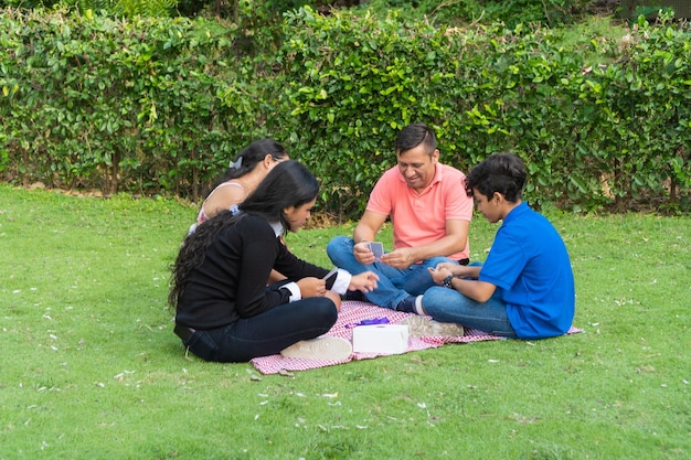 Família jogando jogos de tabuleiro no piquenique ao ar livre