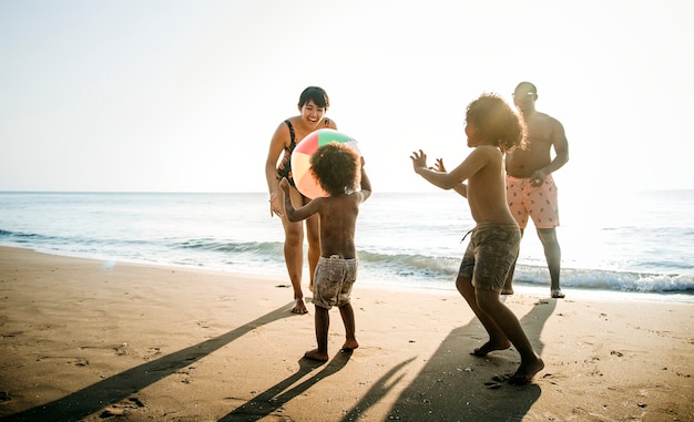 Foto família jogando juntos na praia