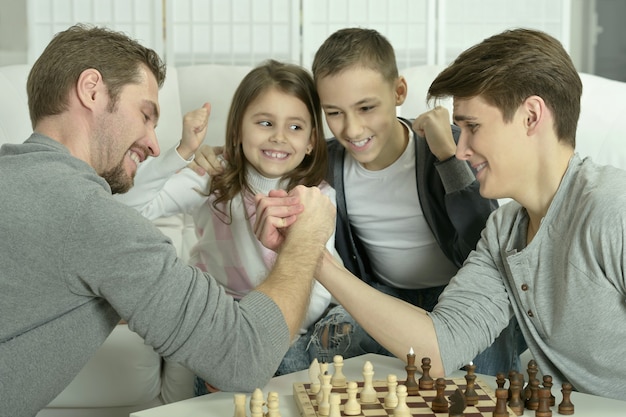 Família jogando xadrez em uma mesa em casa