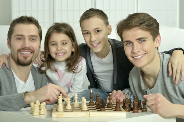 Família jogando xadrez em uma mesa em casa
