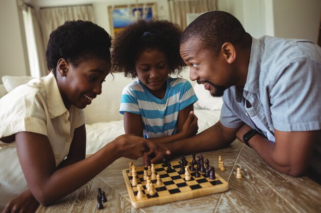 Família jogando xadrez juntos em casa, na sala de estar