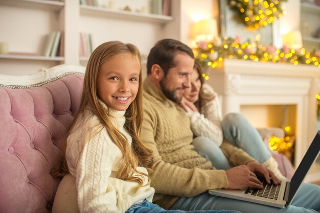 Família jovem assistindo algo em um laptop