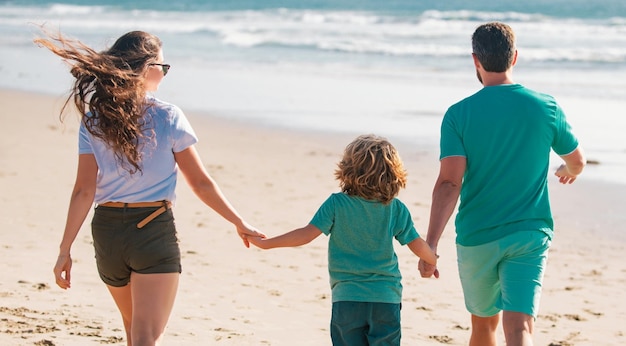 Família jovem caminhando na praia jovem família feliz se divertindo juntos na praia do mar