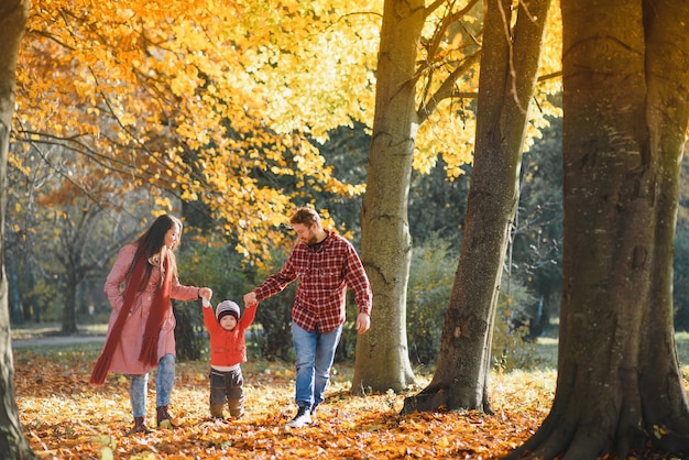 Família jovem caminhando no parque. Outono.
