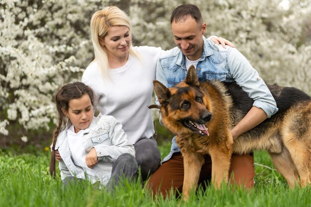 Foto família jovem com crianças e cão a divertir-se na natureza
