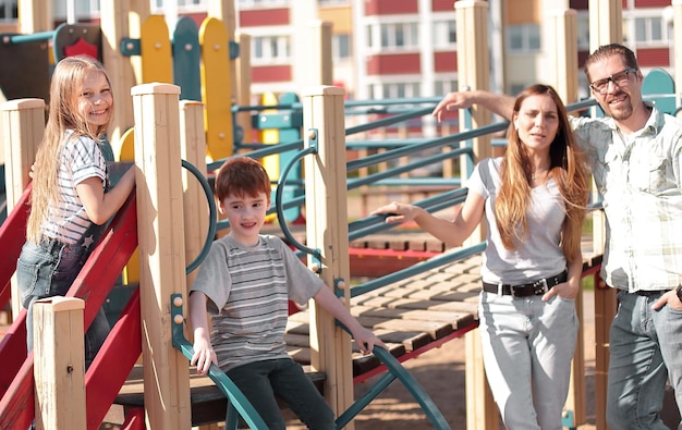 Família jovem com crianças se divertindo no Playground o conceito de paternidade