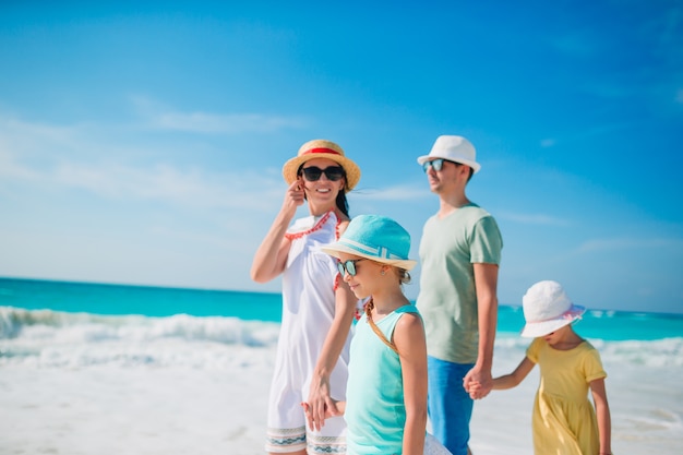 Família jovem com dois filhos em férias na praia