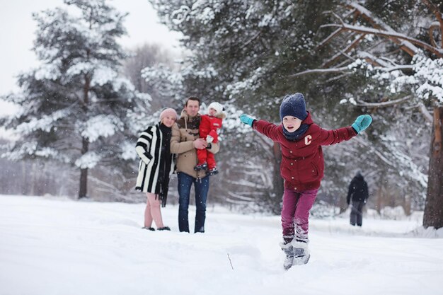 Família jovem com filhos caminhando no parque de inverno Caminhada de inverno de pais com filhos Caminhando em um fim de semana de férias no inverno