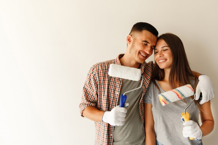 Família jovem com rolos de pintura renovando