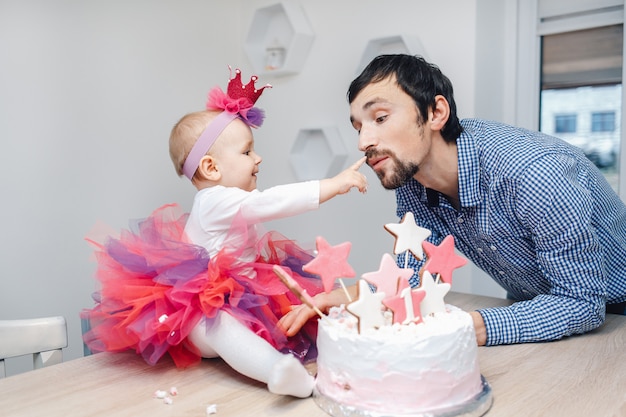 Família jovem comemorando aniversário com um bolo