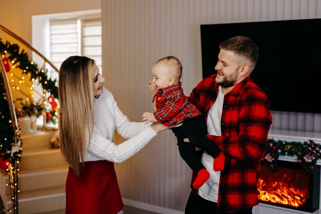 Família jovem comemorando o Natal em casa. Família jovem feliz aproveitando o tempo de férias juntos.