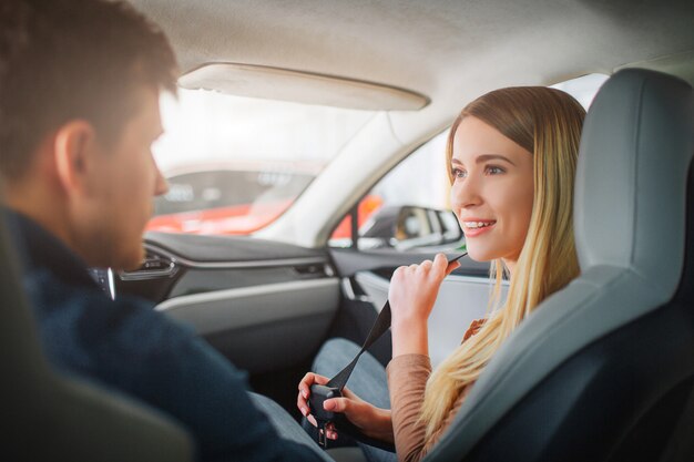 Família jovem comprando seu primeiro carro elétrico no showroom