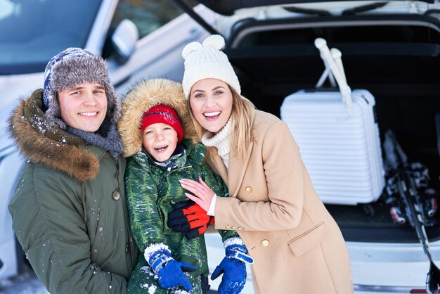 Família jovem durante a mala do carro da viagem de inverno em bacground. Foto de alta qualidade