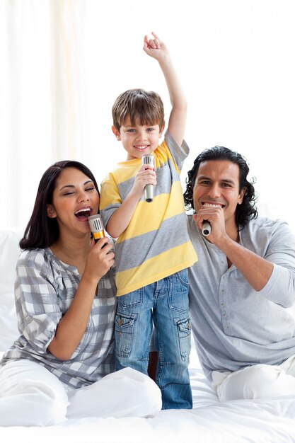 Família jovem e animada cantando com microfones