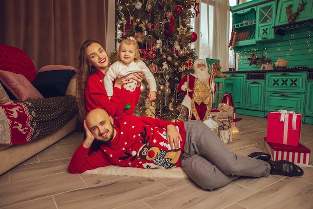 Família jovem e feliz celebrando o Natal e o Ano Novo juntos em casa