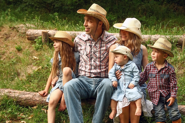 Família jovem e feliz com crianças cowboys