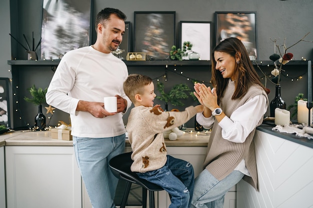 Família jovem e feliz passando algum tempo juntos na cozinha em casa no Natal