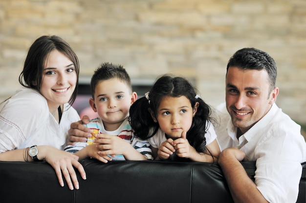 Família jovem e feliz relaxando e se divertindo em uma casa moderna indooor