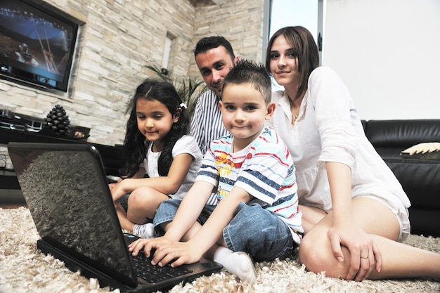 Família jovem e feliz relaxando e se divertindo em uma casa moderna indooor