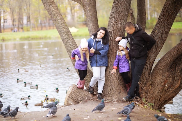 Família jovem em um passeio no parque outono em um dia ensolarado. felicidade por estarmos juntos.